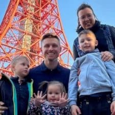 A family poses for a photo in front of the eiffel tower.