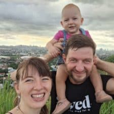 A man and woman with a baby on their shoulders.